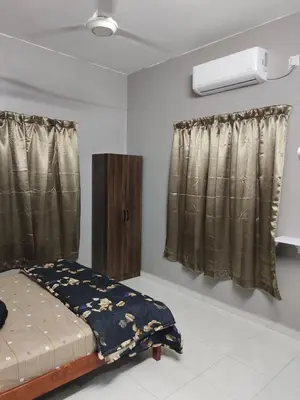 a bedroom with a bed and a window with curtains at DeStay Taiping in Taiping