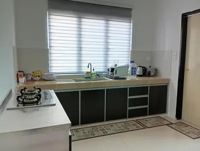 a kitchen with a stove and a counter top at Jwa Vacastay in Lumut