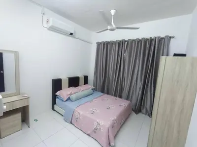a bedroom with a bed with pink sheets and pillows at Jwa Vacastay in Lumut