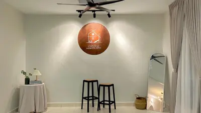 a room with two stools and a clock on the wall at Cozy Stay Bertam in Kepala Batas