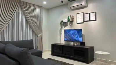 a living room with a couch and a flat screen tv at Cozy Stay Bertam in Kepala Batas