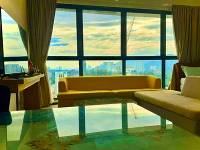 a living room with a couch and a large window at Premium 5 queen bed luxury 2BR suites infinity pool netlfix in Jelutong