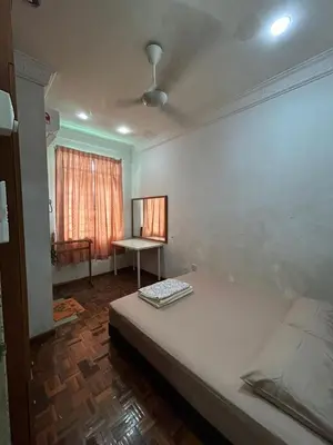 a room with a bed and a table in it at Double Storey Terrace House in Perai