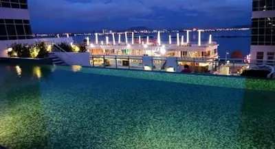 a large swimming pool on the roof of a building at night at Seaview Seafront Duplex in Town with WiFi & Full Kitchen 23 in George Town