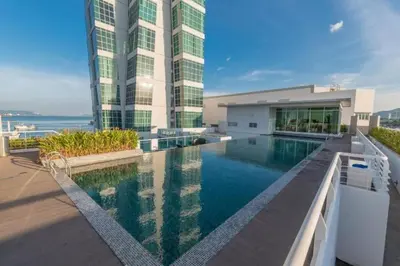 a large building with a swimming pool in front of a building at Seaview Seafront Duplex in Town with WiFi & Full Kitchen 23 in George Town