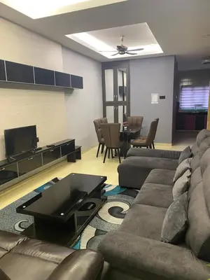 a living room with a couch and a tv and a table at Budget Homestay Lahat in Ipoh