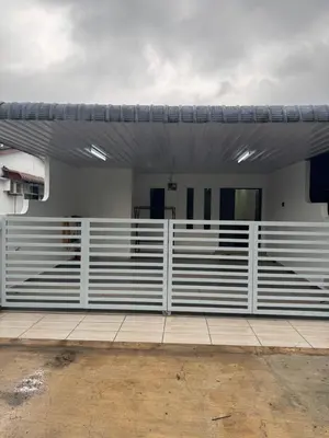 a white fence in front of a house at Wika Homestay in Lunas