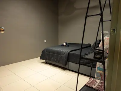 a bedroom with a bed with a black comforter at NDD Homestay in Sitiawan