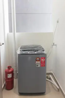 a small refrigerator in a room with a red fire extinguisher at Iconic Regency by Stellar ALV in Bayan Lepas