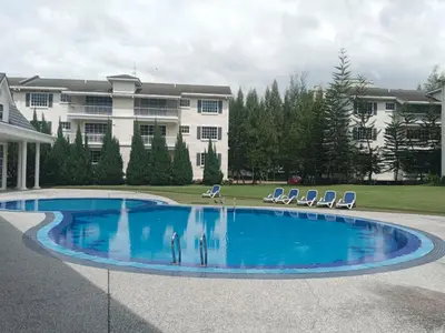 a large swimming pool in front of a building at Fatty House in Kampar