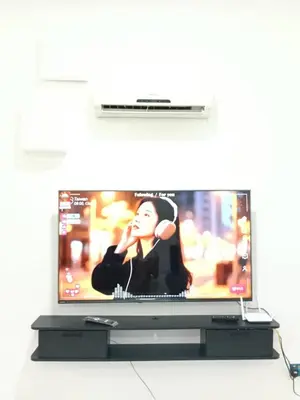a television screen with a woman playing a video game at Fatty House in Kampar