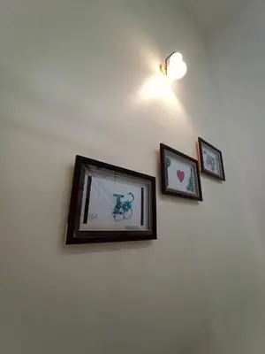 three framed pictures on a white wall with a light at Cheerfull-Cozy Japanese Style in Bukit Mertajam