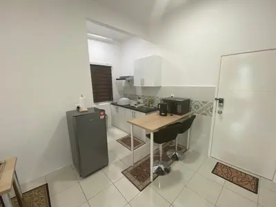 a small kitchen with a table and a refrigerator at Anderson Residency Ipoh Wifi Pool Islam in Ipoh