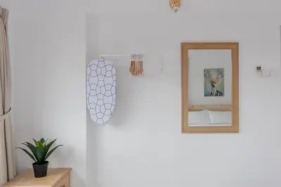 a white room with a mirror and a plant at Eastern Apt, Jelutong in Jelutong