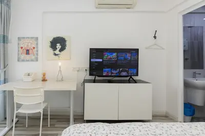 a living room with a white desk with a tv on it at Eastern Apt, Jelutong in Jelutong