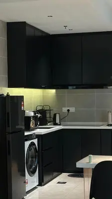 a kitchen with black cabinets and a washing machine at IPOH City Centre ICC Suites by HWC in Ipoh