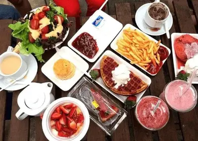 a wooden table with many dishes of food and drinks at IRDINA HomestayMuslim's 2 at Emerald Avenue Brinchang Centrum in Brinchang