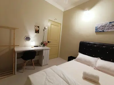 a bedroom with a bed and a desk and a table at Inap Kluster Height , Kuala Kangsar in Kuala Kangsar