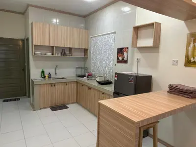a large kitchen with wooden cabinets and a refrigerator at Family Stay at Quintet A3A-3A-6 in Tanah Rata