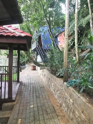 a brick walkway leading to a house with trees at KK Farm Stay in Ringlet