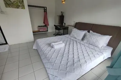 a bedroom with a bed with a white comforter at Aeden Villa Roomstay & Homestay in Kuala Kangsar