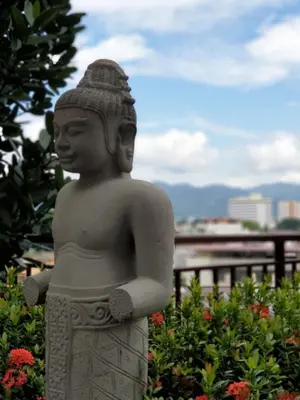 a statue in front of a garden with flowers at Ipoh town The Majestic Rumi 3R2B 8 paxs in Ipoh