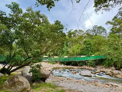 a bridge over a river with a train crossing it at Camp Site in Tapah