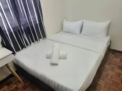 a white bed with two pillows on top of it at Cool memories smart stay in Tanah Rata