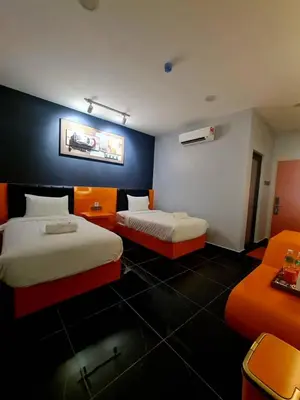 two beds in a room with orange and white at Eng Wan Hotel in Kamunting