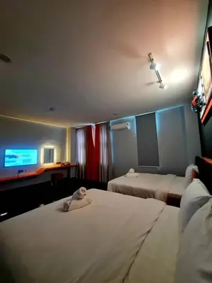 a hotel room with two beds and a flat screen tv at Eng Wan Hotel in Kamunting