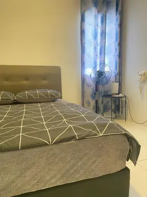 a bedroom with a bed and a fan at Qaseh Homestay Cameron Highlands The Quintet Apartment Tanah Rata in Tanah Rata
