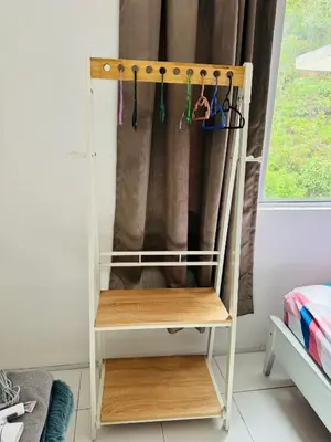 a wooden shelf with clothes hooks in a room at AYAAN QUINTET FAMILY HoMESTAY Free Parking in Tanah Rata