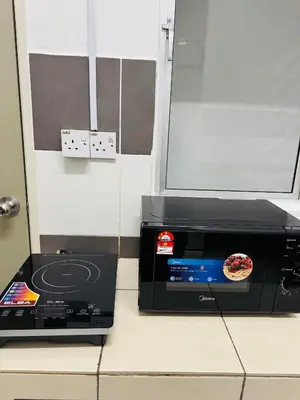 a microwave sitting on a counter with a pizza inside at AYAAN HOMESTAY HILL VIEW INN 2 FREE Wifi and Netflix in Cameron Highlands