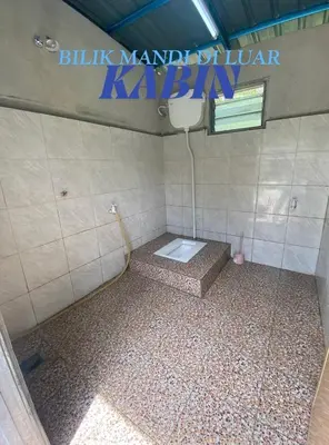 a bathroom with a toilet in a tiled room at Kabinstay suasana dusun in Kampung Lubuk Buaya