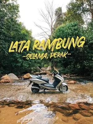 a motor scooter parked in a river with a sign at Kabinstay suasana dusun in Kampung Lubuk Buaya