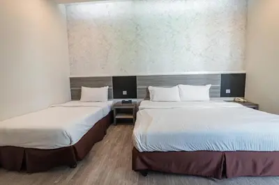 two beds in a hotel room with at Indra Hotel Ipoh in Ipoh