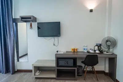 a room with a desk with a tv and a chair at Indra Hotel Ipoh in Ipoh