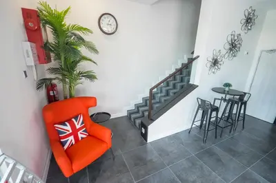 a living room with an orange chair and a table at Indra Hotel Ipoh in Ipoh