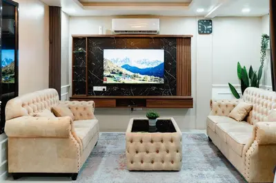 a living room with two couches and a flat screen tv at S&A Homestay in Sungai Petani