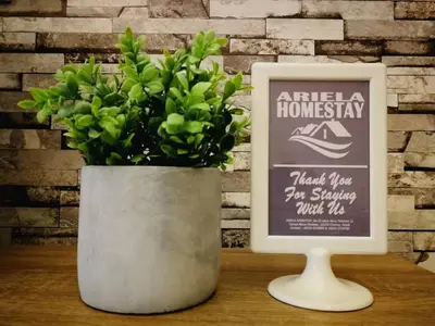 a vase with a plant in it next to a sign at Ariela Homestay in Ipoh