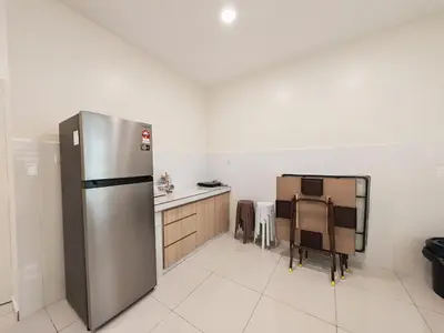 a kitchen with a stainless steel refrigerator and a table at No 8 Homestay in Pangkor