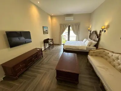 a living room with a couch and a bed and a tv at The Ranch in Ipoh