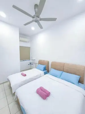 two beds in a room with a ceiling fan at Home in Ipoh in Ipoh