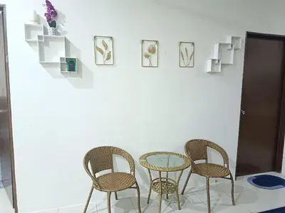 three chairs and a glass table in a room at Amirah homestay in Kampong Sungai Wangi Dalam
