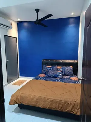 a bed in a room with a blue wall at SR Kampar 2-Storey LANDED HOMESTAY in Kampar