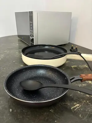 a black frying pan and a bowl on a counter at Comfy21 Homestay Ipoh near Sunway Tambun in Ipoh