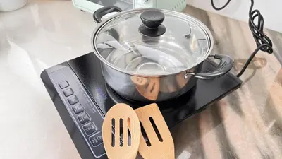 a pot on top of a stove with a pair ofippers at Single Terrace at Canning Ipoh Newly Renovated in Ipoh