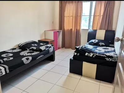 a room with two beds and a chair in it at Ummu's homestay in Tanah Rata