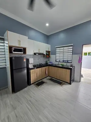 a kitchen with blue walls and a black refrigerator at Kak Nah Homestay A Mus'lim Only in Taiping