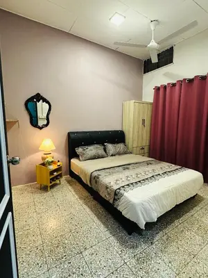 a bedroom with a bed and a red curtain at M&M Bendi Homestay in Lunas